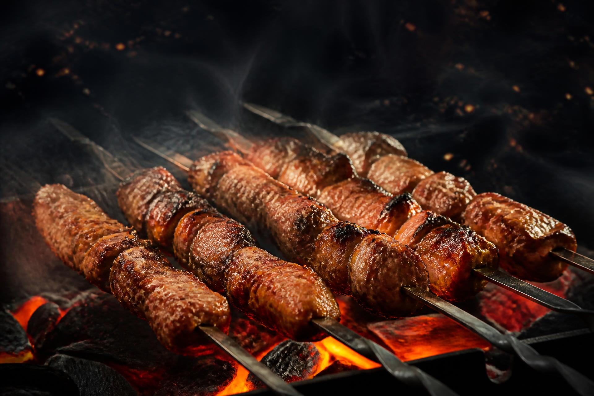 Grillie skewers grilling over glowing charcoal embers